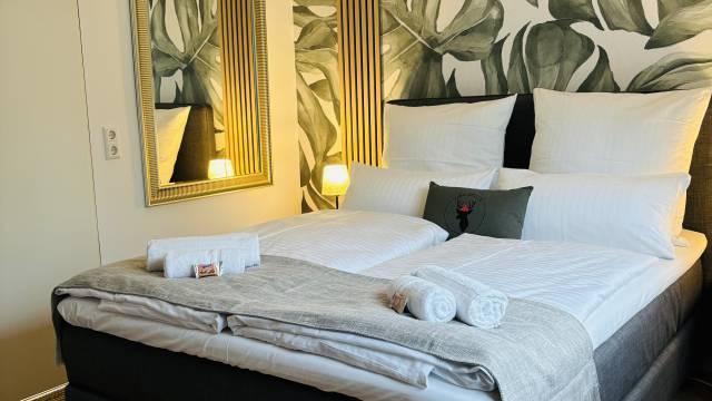 Doppelbett im Schlafzimmer Rema Homes Apartments